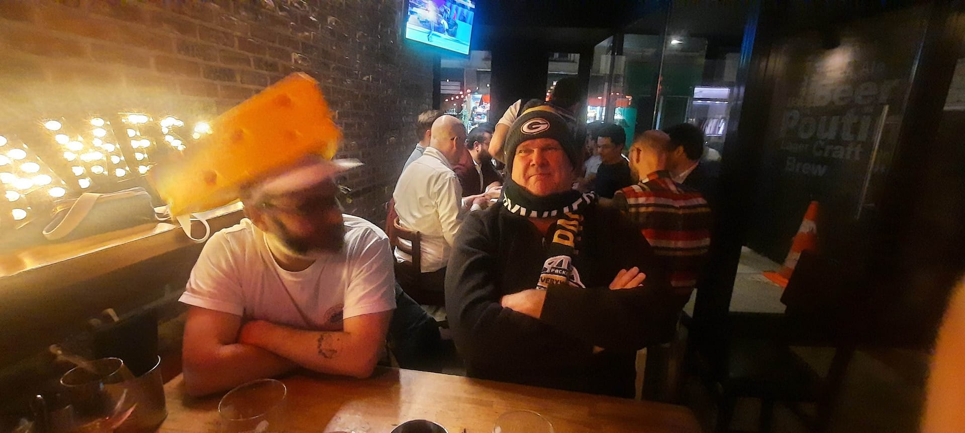 Packers fan wearing a cheesehead at the bar